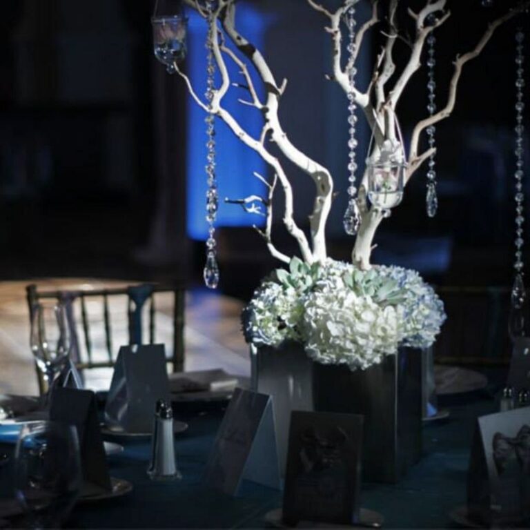 a wedding table setting with a pin spot and blue uplighting